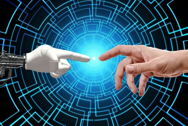 A human hand and a robot hand pointing at each other against a blue IT consultancy digital tunnel background.