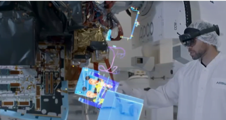 Man using virtual reality equipment to interact with 3d models of spacecraft components.