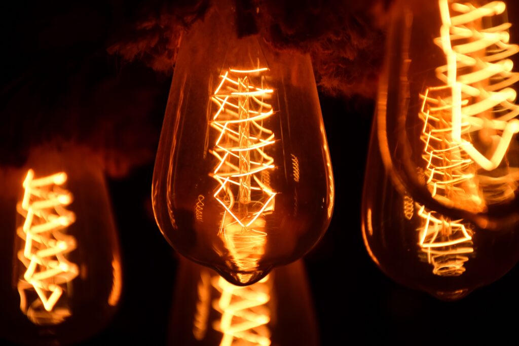 Close-up of glowing filament light bulbs showing detailed, intricate patterns and warm, amber light for IT services business clients.