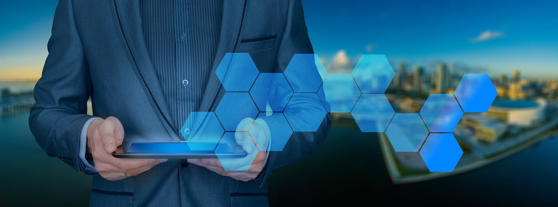 Businessman using a digital tablet with futuristic holographic icons, with a city skyline in the background.